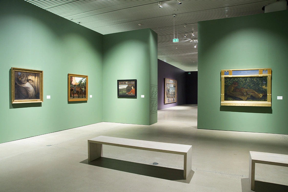 paintings hanging on the green walls in the aros-exhibition