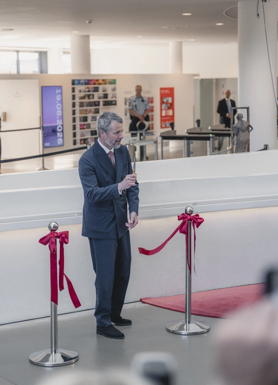 The king cuts the ribbon